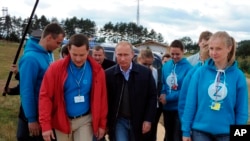 Russian President Vladimir Putin, center, arrives at a meeting with participants in the youth educational forum at the Seliger youth camp near Lake Seliger, some 450 kilometres (281 miles) northwest of Moscow, in Tver region, Russia, Friday, Aug. 29, 2014