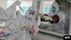 ရန်ကုန်မြို့ လှိုင်မြို့နယ်က Quarantine စင်တာတခုမှာ ကိုရိုနာဗိုင်းရပ်စ် စစ်ဆေးဖို့ ပြင်ဆင်နေတဲ့ ကျန်းမာရေးဝန်ထမ်းများ။ (ဇူလိုင် ၁၆၊ ၂၀၂၀)