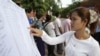 A woman finds her name on a list during a local commune election in Phnom Penh, June 3, 2012.