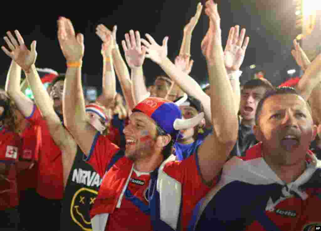 Costa Rica soccer fans celebrate a goal scored by their team, as they watch the World Cup round of 16 match against Greece on a live telecast inside the FIFA Fan Fest area on Copacabana beach in Rio de Janeiro, Brazil, Sunday, June 29, 2014. (AP Photo/Leo