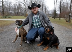 Shane Johnson poses with his dogs outside his home in Tippecanoe, Indiana, Jan. 12, 2017. Johnson was born into extremism. He eventually joined a skinhead group in addition to the KKK but finally decided to quit after getting arrested, stopping drinking and meeting the woman who is now his wife. Leaving was a real fight, though, as even relatives jumped him at a gas station one night after learning he wanted to quit.