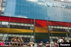 FILE - Tourists on a bus move past a Barclays building as the LGBT rainbow flag is displayed on its digital screens in New York, June 26, 2015. The U.S. Supreme Court had just ruled that constitutional guarantees meant states could not ban same-sex marria