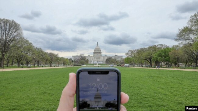 Una persona fotografiando la fachada del Capitolio de Estados Unidos completamente vacío.