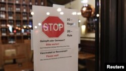 A 2G rule sign, allowing only those vaccinated or recovered from COVID-19 to enter restaurants and other indoor areas, is displayed at the entrance of a restaurant in Berlin, Germany, November 15, 2021.