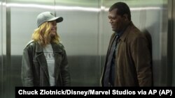 This image released by Disney-Marvel shows Samuel L. Jackson, right, with Brie Larson on the set of "Captain Marvel."