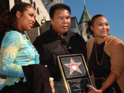 Mantan juara dunia tinju kelas berat AS Muhammad Ali (tengah) berpose dengan dua putrinya, Hana (kiri) dan May May (kanan), di Hollywood Walk of Fame, Los Angeles, CA, 11 Januari 2002. (AFP/LUCY NICHOLSON)