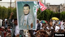 FILE - Supporters of the Shi'ite Houthi hold a poster of the group's leader Abdul-Malik al-Houthi during an anti-government rally in Sanaa, August 29, 2014.