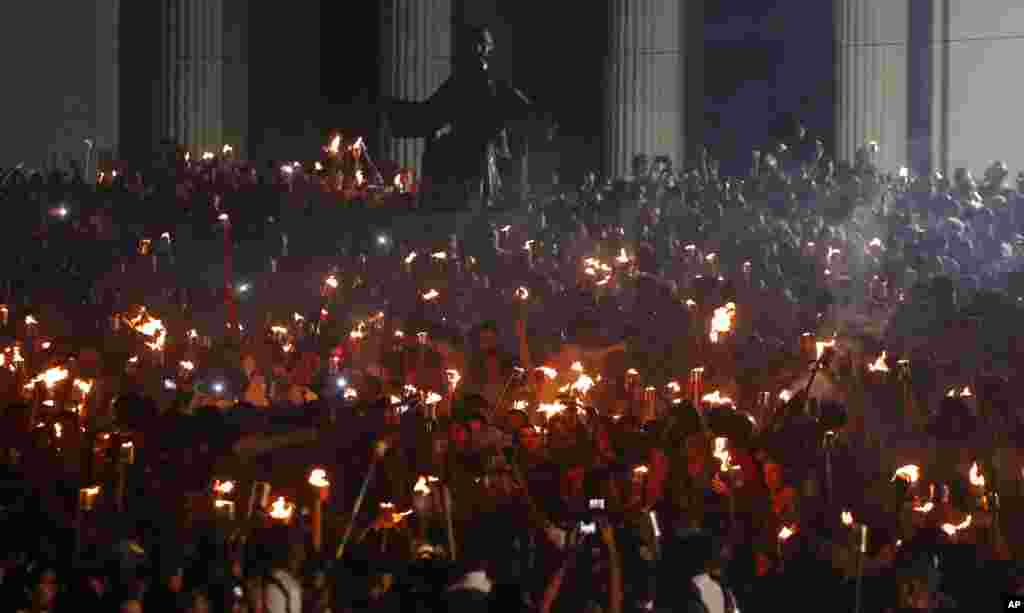 Ribuan warga Kuba membawa obor di pintu masuk Universitas Havana untuk memperingati HUT ke-165 pahlawan kemerdekaan Kuba, Jose Marti, serta menghormati pemimpin revolusi Fidel Castro di Havana.