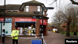 FILE - A police officer stands at a cordon around the bench where former Russian intelligence agent Sergei Skripal and his daughter Yulia were found after they were poisoned, in Salisbury, Britain, March 11, 2018. 