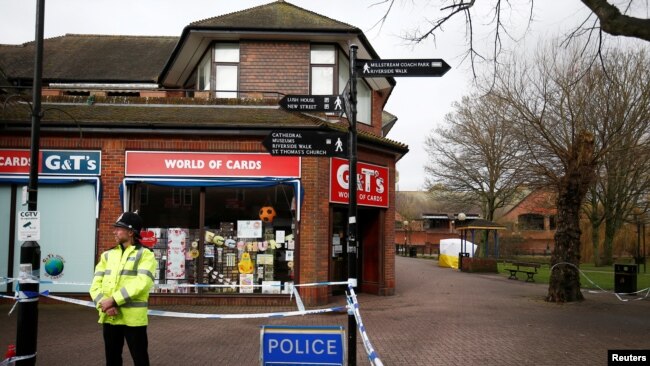 A police officer stands at a cordon around the bench where former Russian intelligence agent Sergei Skripal and his daughter Yulia were found after they were poisoned, in Salisbury, Britain, March 11, 2018.