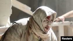 An injured woman reacts at a site hit by airstrikes in the rebel held area of Old Aleppo, Syria, April 28, 2016.