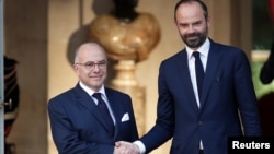 Newly-appointed French Prime Minister Edouard Philippe (R) is greeted by his predecessor Bernard Cazeneuve (L) during a handover ceremony at the Hotel Matignon, in Paris, France, May 15, 2017. 