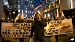 A protester shouts slogans during a demonstration against government plans to expand the number of auctions of foreclosed properties, in central Athens, Feb. 21, 2018. 
