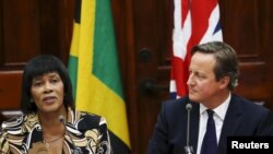 Jamaica's Prime Minister Portia Simpson-Miller (L) addresses the audience as her British counterpart David Cameron looks on during a bilateral meeting at Jamaica House in Kingston, Sept. 29, 2015. 