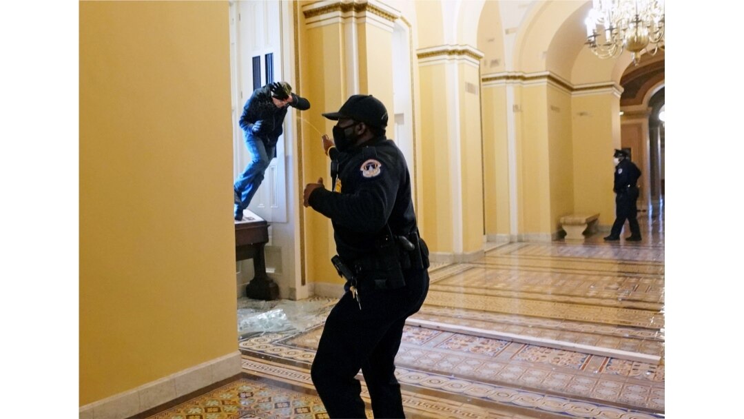 Seorang petugas polisi Capitol AS menembakkan semprotan merica ke seorang pengunjuk rasa yang mencoba memasuki Gedung Capitol di Washington, AS, 6 Januari 2021. (Foto: Reuters)