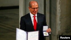 화학무기금지기구의 아흐메트 위쥠쥐 사무총장은이 10일 노르웨이 오슬로에서 열린 시상식에서 상패를 들어보이고 있다.