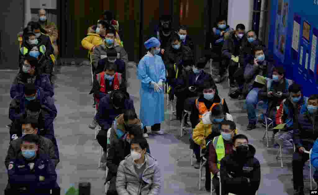 People wait on chairs after being inoculated with a COVID-19 vaccine at the Chaoyang Museum of Urban Planning in Beijing.