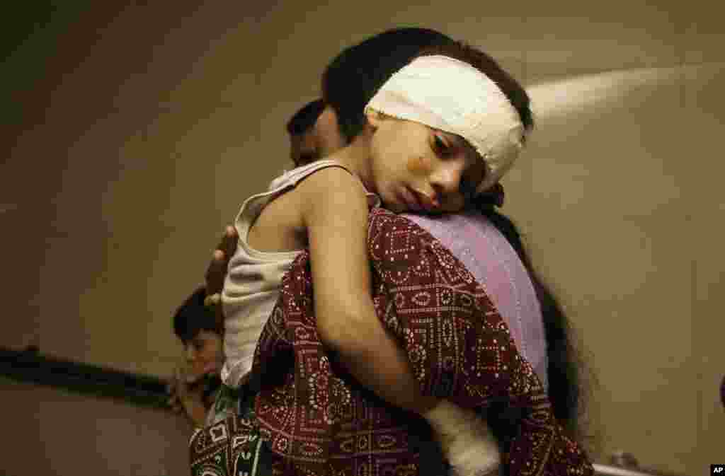A Pakistani mother holds her wounded child at a hospital in Karachi, Pakistan, November 21, 2012.