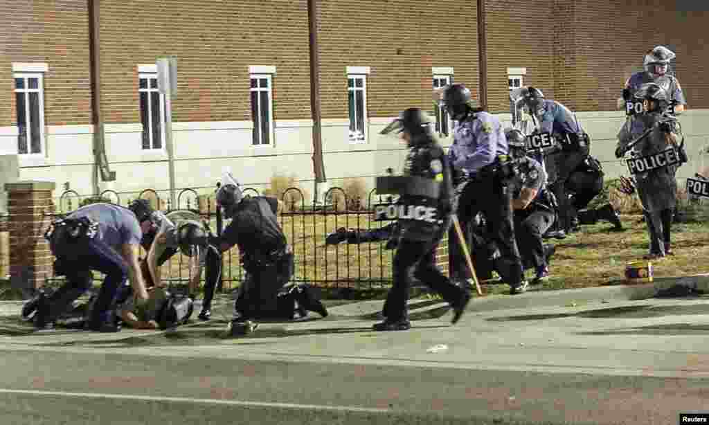 Police officers respond to a fellow officer hit by gunfire outside the Ferguson Police Headquarters in Ferguson, Missouri. Two police officers were shot in what officials called an ambush in the St. Louis suburb.