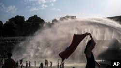 People cool down in the fountains of the Trocadero gardens in Paris, Thursday July 25, 2019, when a new all-time high temperature of 42.6 degrees Celsius hit the French capital.