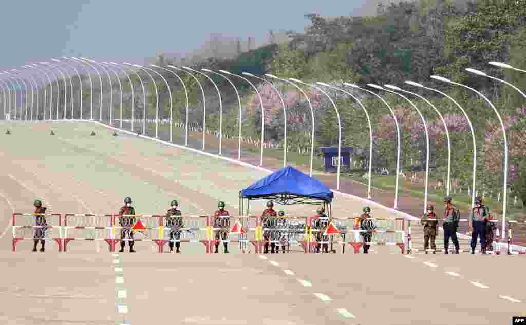 Soldiers stand guard on a blockaded road to Myanmar's parliament in Naypyidaw after the military detained the country's de facto leader Aung San Suu Kyi and the country's president in a coup.