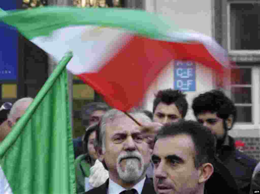 A protester waves the Iranian flag, as he demonstrates in front of the Iranian embassy to show solidarity to the people of Iran and others fighting for freedom, in Brussels, Monday, Feb. 14, 2011. (AP Photo/Yves Logghe)