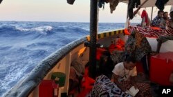 Seorang migran membaca ayat-ayat Al-Qur'an di atas kapal penyelamat "Open Arms" berbendera Spanyol, saat mereka tiba di dekat pantai Lampedusa, Laut Mediterania, 15 Agustus, 2019.