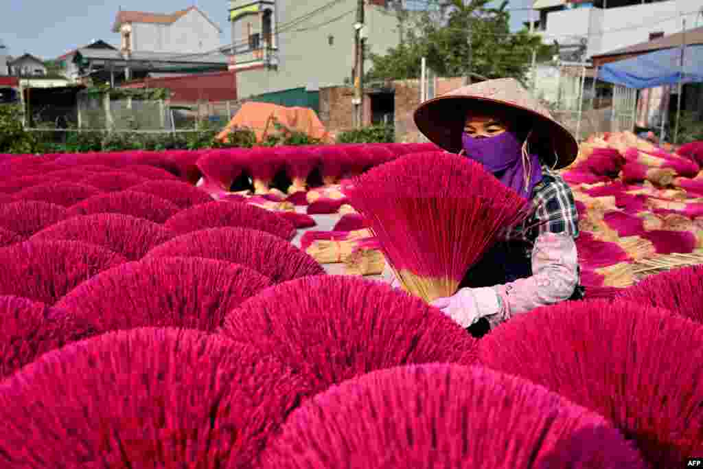 A worker arranges dried incense sticks in a courtyard in Quang Phu Cau village on the outskirts of Hanoi ahead of Lunar New Year celebrations, known in Vietnam as Tet.