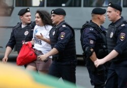 Police officers detain a supporter of Russian investigative journalist Ivan Golunov during a march in Moscow, Russia, Wednesday, June 12, 2019.