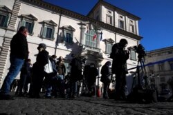 Reporters stand at the entrance of Rome's Quirinale Presidential Palace, Jan. 26, 2021, ahead of Prime Minister Giuseppe Conte offering his resignation.