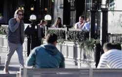 People sit in an outdoor restaurant area in Christchurch, New Zealand, June 8, 2020.