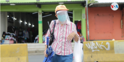 Algunas personas en Nicaragua han decidido extremar sus medidas de seguridad al ir a centros de compras por temor a contagiarse de COVID-19. Foto VOA.