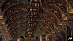 U.S. Vice President Joe Biden, right, walks with Chinese Vice President Xi Jinping, left, as they visit the South Bridge in Dujiangyan on the outskirts of Chengdu, in southwestern China's Sichuan province, Sunday, Aug. 21, 2011