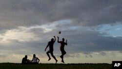 FILE - Young men play a game of rugby at sunset in Nuku'alofa, Tonga. 