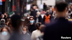 People wearing protective masks walk in the Montorgueil street in Paris amid the coronavirus outbreak in France, Feb. 25, 2021.