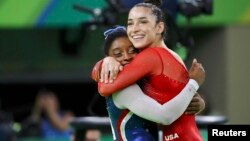 Simone Biles (L) and Aly Raisman celebrate winning gold and silver respectively at the women's individual all-around final in Rio de Janeiro, Brazil, Aug. 11, 2016.