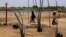 FILE - Chadian women walk past destroyed homes, in the Lake Chad shore village of  N'Gouboua, March 5, 2015, following a scorched-earth attack by Boko Haram militants.