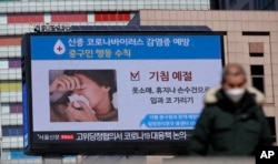A huge screen about precautions against the COVID-19 is seen in downtown Seoul, South Korea, Feb. 23, 2020.