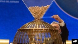 A worker prepares the numbered lottery balls at Madrid's Teatro Real opera house during Spain's bumper Christmas lottery draw known as El Gordo, or The Fat One, in Madrid, Spain, Sunday, Dec. 22, 2019. 