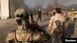 Iraqi security forces stand guard near the building of the government office in Basra, Iraq, Sept. 6, 2018. 