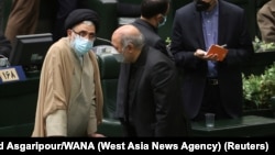 资料照片：伊斯梅尔·哈提卜(左)在伊朗德黑兰的伊斯兰议会出席对易卜拉欣·莱希(Ebrahim Raisi)总统内阁的信任投票。