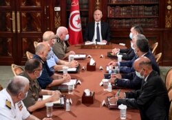 Tunisia's President Kais Saied, center, leads a security meeting with members of the army and police forces in Tunis, July 25, 2021.