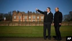 Britain's Prime Minister Keir Starmer, left, speaks with Germany's Chancellor Olaf Scholz in the garden of the Chequers, in Aylesbury, England, Feb. 2, 2025.