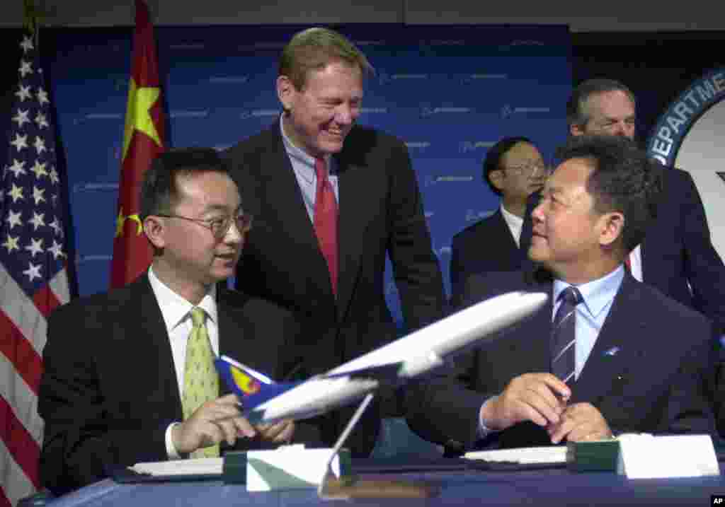 2001年10月2日，波音商用飞机CEO Alan Mulally, 中国南方航空公司的Li Fenghua 和海南航空公司的任卫东（译音）在美国商务部交谈。中国当时购买了30架波音737客机