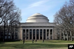 FILE - Students walk past the "Great Dome" atop Building 10 on the Massachusetts Institute of Technology campus in Cambridge, Mass, April 3, 2017. (AP Photo/Charles Krupa, File)