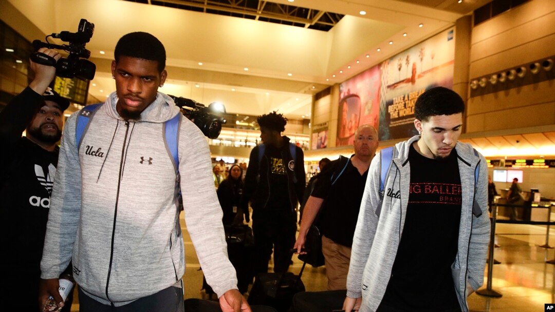 Ba cầu thủ của đội bóng rổ trường đại học UCLA, Cody Riley (trái), LiAngelo Ball (phải), và Jalen Hill (giữa phía sau) giữa các phóng viên báo chí khi họ về đến phi trường LAX ở Los Angeles chiều tối thứ Ba 14/11.