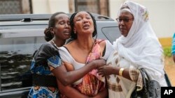 Relatives and friends grieve during the funeral of Patrick Ndikumana, Friday, July 3, 2015, in Bujumbura, Burundi. According to relatives Ndikumana was killed in the police attack in Jabe neighborhood last week. A U.N. observer mission concluded Thursday