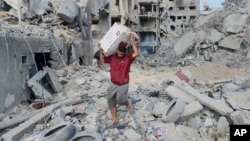 A Palestinian man salvages his belongings from the rubble after an Israeli airstrike in Gaza City on Oct. 10, 2023. The United Nations estimates that at least 200,000 of Gaza’s 2.2 million residents have been displaced in the fighting between Hamas militants and Israeli forces.