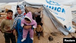 Syrian refugees leave their tents after heavy rain, Al-Zaatari refugee camp, Mafraq, Jordan, Jan. 8, 2013.