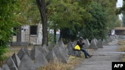 Місцевий житель серед бетонних перешкод у місті Покровськ Донецької області, 20 жовтня 2024 року. Західні оглядачі наголошують, що важливим є не лише завершення війни, а і безпекові гарантії для України на майбутнє. Genya SAVILOV/AFP